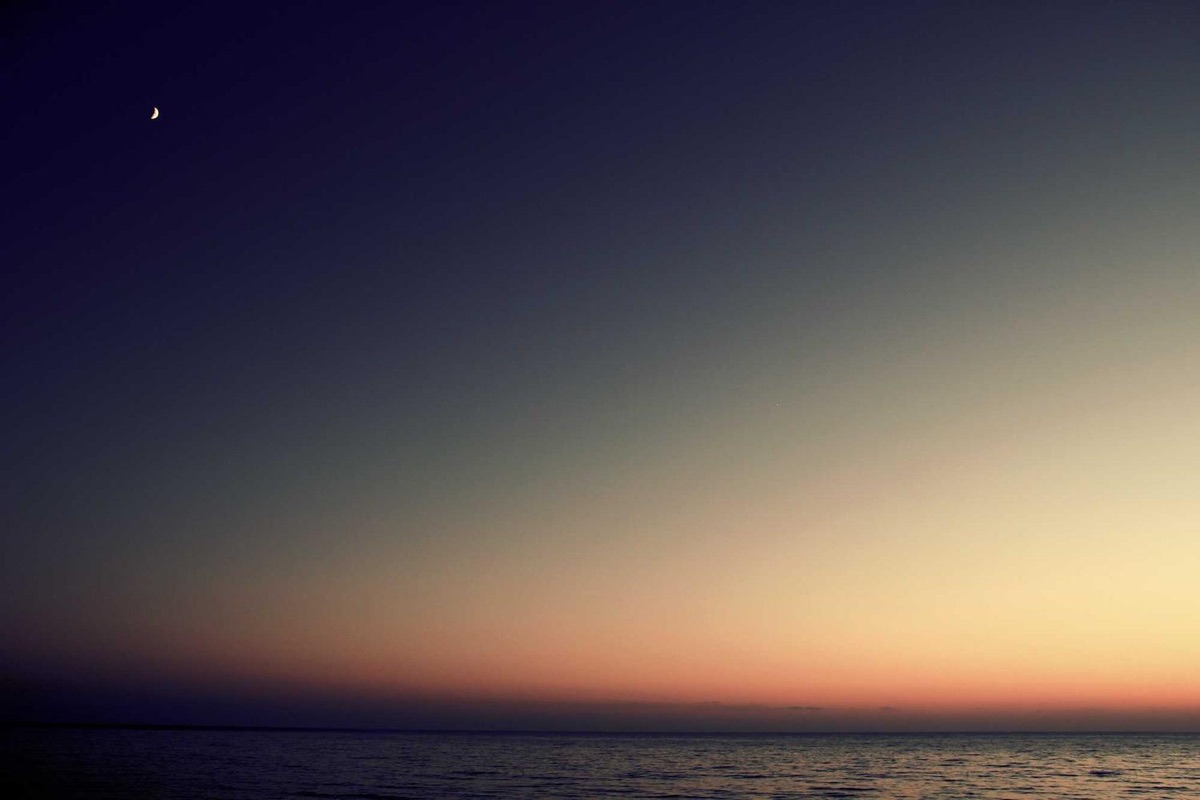 Dusk sky fading from blue to orange over the sea.
